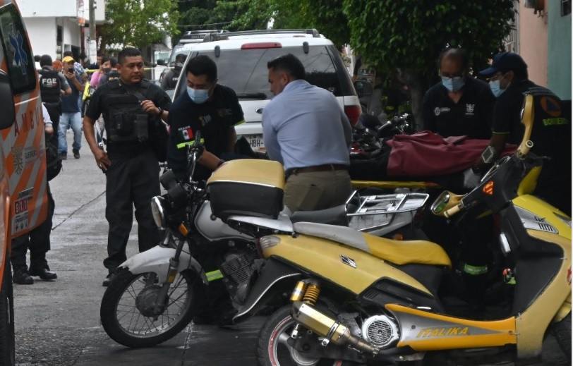 Hombres revisando motocicletas en el lugar donde se cometió el asalto a un taller